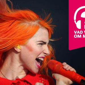 Hayley Williams sjunger i en mikrofon som hon hålleri handen.