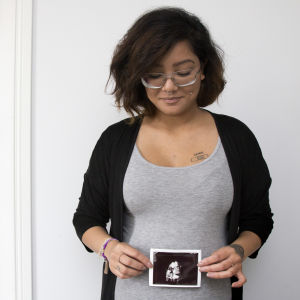 Emilia Jansson håller i en ultraljudsbild av sin bebis. Hon håller totot mot magen. 