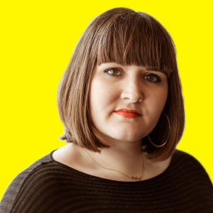 Anna Brotkin katsoo kameraan keltaisessa kuvassa.