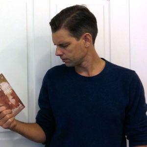 Alex Schulman håller i boken "Glöm mig".