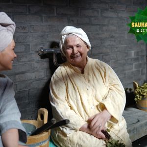 Tuija Pehkonen ja Anja Pohjola istuvan penkillä pyyhkeet päässään ja juttelevat.