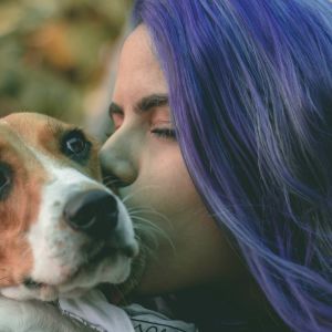 Nainen suutelee koiraa