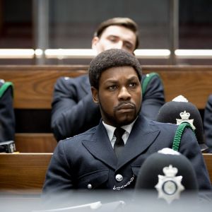 Konstaapeli Leroy Logan (John Boyega) istuu uniformupukuisena muiden poliisien joukossa luentosalissa. Kuva elokuvasta Small Axe: Red, White and Blue