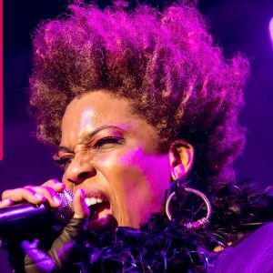 Macy Gray sjunger i en mikrofon som hon håller i handen.