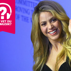 Shakira ler och vinkar mot kameran.