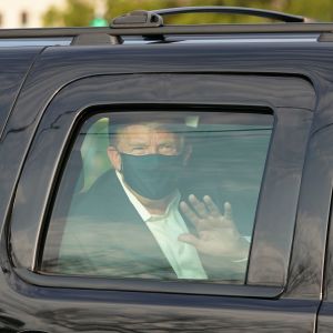 Trump vinkade åt sina anhängare från en bil på söndagen. Donald Trump vinkar från fönstret på en svart bil.