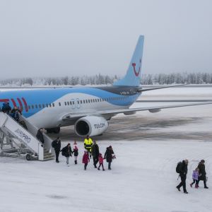 Jouluturisteja tulossa koneesta Rovaniemen lentokentällä