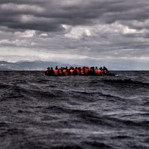 Migranter med flytvästar i en fullproppad båt.