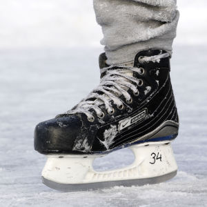 Fötter med ishockeyskridskor på is