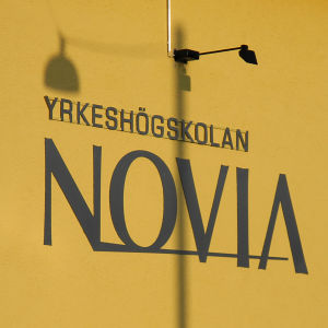 Yrkeshögskolan Novias skylt på gul vägg.