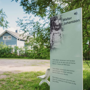 Husens och stadsdelens historia skildras på skyltar. QR-koodilla varustettu kyltti, jossa ruotsinkielistä tekstiä ja otsikko "Walter Johansson" Paraisten Vanhalla Malmilla opastamassa matkailijoita.
