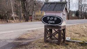 Värdshuset i Box håller öppet men kunderna är få. Ett ljusrött miniatyrhus vid vägkanten. På huset finns en skylt med texten B & B open.