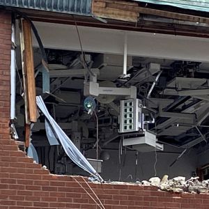 Halvt riven tegelvägg. Inne syns elsladdar och elektronik.