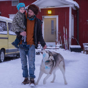Perustulokokeiluun osallistuva Juha Järvinen pihamaallaan Jurvassa, yhdessä lapsen ja koiransa kanssa.