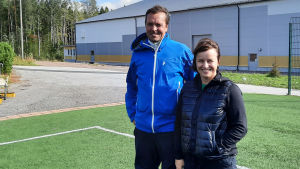 Föräldrarna Malin och Sami Lahdensuo vill hjälpa sonen förverkliga sina drömmar. En man och en kvinna står vid sidan av en fotbollslan. De tittar in i kameran och ler.