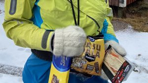 Dagens matsäck består av choklad, kex och smörgås. Charlotta håller upp choklad, kex och smörgås som hon ska ta med på kajakturen.