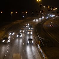 Biltrafik på en motorväg en mörk morgon.