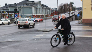 Jörgen Wollsten cyklar till jobbet varje dag. I bakgrunden syns den icke cykelvänliga bron vid Mannerheimgatan. Man cyklar i centrum av Borgå.