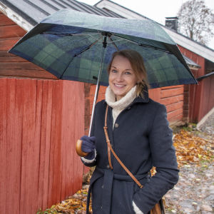 Tanja Holmberg står framför en rad med gamla hus i Borgås Gamla stan.