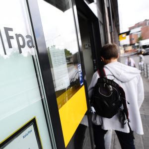 En person med kort hår och ryggsäck går in genom dörren till FPA:s kontor.