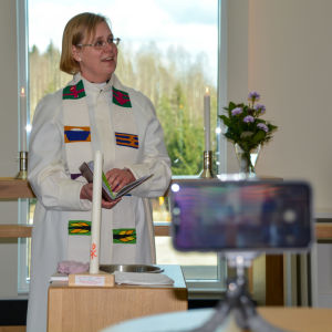 Ceremonin krävde en del extratänk också av kyrkoherde Camilla Ekholm. Kyrkorden står framför dopfunten, tittar upp och ler.