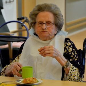 103-åriga Aune Sola njuter av hembakta kanelbullar. En äldre gråhårig dam äter bulla.