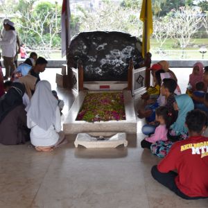 Människor sitter vid Sukarnos grav. 