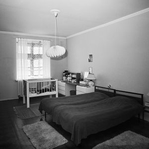 Mustavalkoinen kuva 1960-luvun kerrostalon makuuhuoneesta
