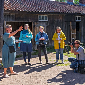 Ihmisryhmä Turussa Luostarimäen museoalueen puutalojen keskellä.