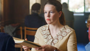 En hjälpande hand. Josefin Neldén spelar Maggan som blir ett språkrör för de mest utsatta. Karaktären maggan räcker över en mapp vid ett middagsbord.
