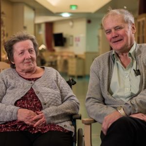 äldre par sitter och småler