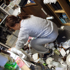 Kvinna sopar upp sönderslagna tallrikar på en restaurang, efter jordskalv i Fukushima 13.2.2021