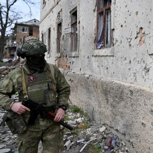 Rysk soldat utanför ett hus i Ukraina.