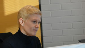 Kriminalkommissarie Maria Sainio vid Pargaspolisen. Maria Sainio, en dam med kort, blont hår och svart tröja sitter vid sin dator.