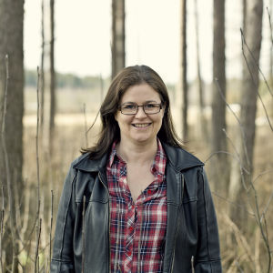 Dirigenten Anna-Maria Helsing i civila kläder framför en skog