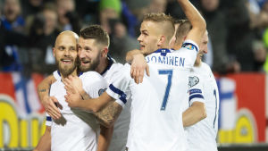 Suomen miesten jalkapallomaajoukkueen pelaajat halaavat.