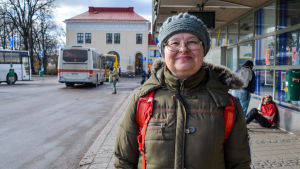 Maria-Liisa Mäki tror att säkerhetsbältena kunde marknadsföras bättre för att få fler att använda dem. En kvinna står utanför Borgå busstation. Hon tittar in i kameran och ler.