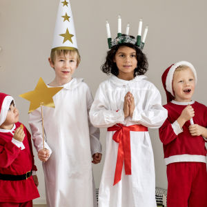 Jouluasuisia lapsia: tonttuja, enkeli, tiernapoika ja Lucia-neito.