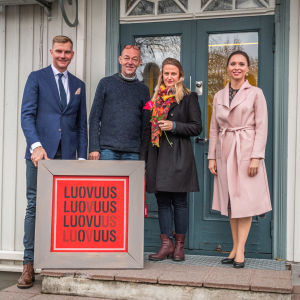 I samband med att köpebrevet undertecknades, överräckte Pyttis kommun också konstverket "Luovuus" av Pyttiskonstnären Timo Peri åt de nya ägarna. På bilden, från vänster, kommundirektör Jouni Eho, de nya ägarna Vesa Ristimäki och Netta Norro, samt sångaren Emilia Vesalainen-Pellas. Jouni Eho, Vesa Ristimäki, Netta Norro och Emilia Vesalainen-Pellas står på en trappa och håller i ett konstverk med texten Luovuus.