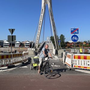 En cyklist svänger från gångbron och ut på cykelgatan.