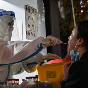  En hälsoarbetare tar ett prov från en kvinna för att testa för covid-19.