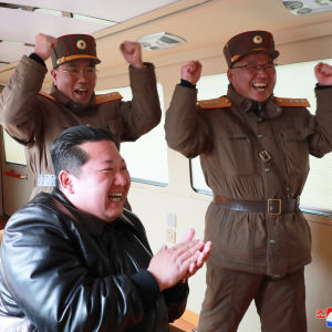 Kim Jong-Un juhlistaa raketin laukaisua sotilaskomentajien kanssa.