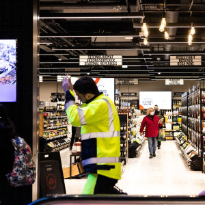 Alko taustalla ja etualalla kulkee ihmisiä.
