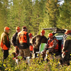 Metsästysporukka aamuvarhaisella metsänlaidassa metsästysreissun jälkeen.
