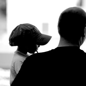 A black-and-white photo of a man holding a child.