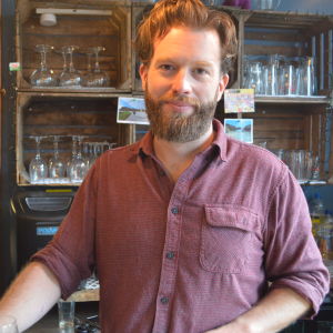 James Kurran äger sin pub. En rådhårig pubägare står bakom sin disk med glasfyllda hyllor i bakgrunden.