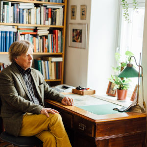 Författaren och filosofen Fredrik Lång sitter vid ett skrivbord.