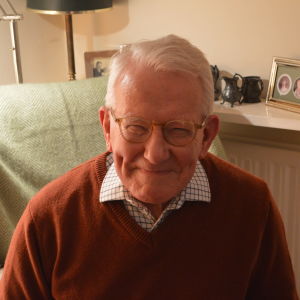 Bob Morris forskar i monarkin. En glad äldre herre i röd tröja och kragskjorta.