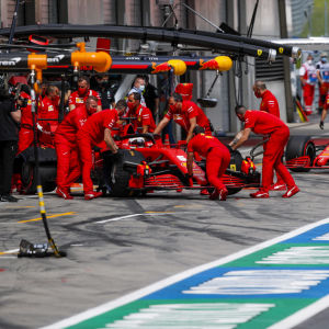 Mekaniker rullar in Ferraribilarna i garaget. 