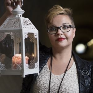 Kirjailija Salla Simukka kynttilälyhty kädessään